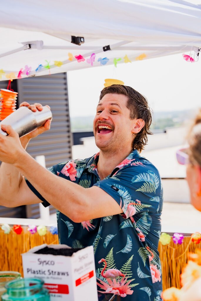 Tom laughing while shaking a cocktail behind the bar