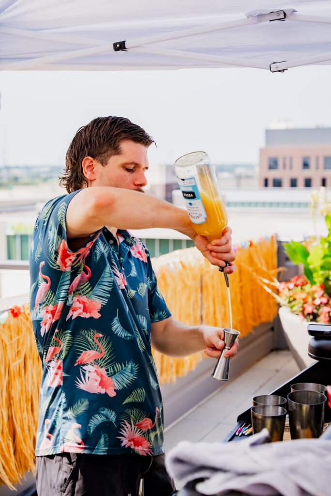Tom pouring from a bottle into a jigger