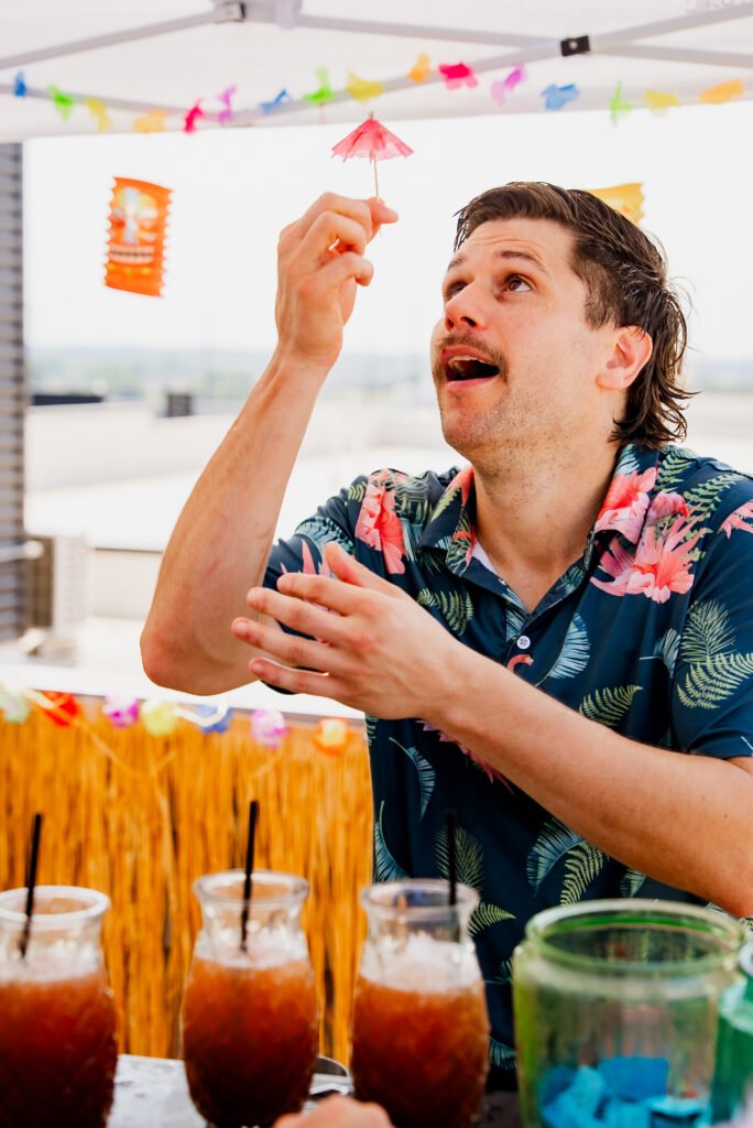 Tom tossing a paper cocktail umbrella
