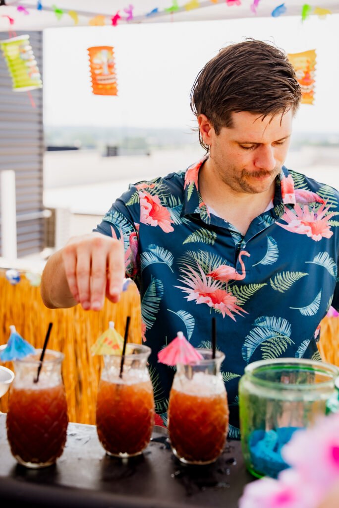 Tom adding umbrella garnishes to three cocktails